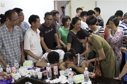 Parents of Wang Linjia, center, are comforted by parents of some other students who were on the Asiana Airlines Flight 214 that crashed at San Francisco International Airport, at Jiangshan Middle School in Jiangshan city, in eastern China's Zhejiang province, Sunday July 7, 2013. Chinese state media have identified the two people who died in the plane crash at San Francisco International Airport on Saturday as Ye Mengyuan and Wang Linjia, students at Jiangshan Middle School in China's eastern Zhejiang province. (AP Photo)  CHINA OUT