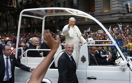 Pope Francis waves from his popemobile as he makes his way into central Rio de Janeiro, Brazil, Monday, July 22, 2013. The pontiff arrived for a seven-day visit in Brazil, the world's most populous Roman Catholic nation. During his visit, Francis will meet with legions of young Roman Catholics converging on Rio for the church's World Youth Day festival. (AP Photo/Victor R. Caivano)