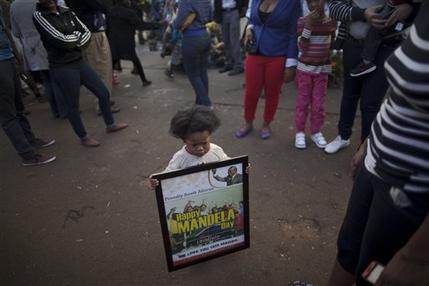 South African Amonra Maluleka, 2, holds a framed picture showing former South African President Nelson Mandela, at the entrance to the Mediclinic Heart Hospital where Mandela is being treated in Pretoria, South Africa, Tuesday, July 9, 2013. Grandson Ndaba Mandela said Tuesday that the ailing former president is very much alive and urged well-wishers to celebrate the life of the anti-apartheid leader ahead of his 95th birthday. (AP Photo/Muhammed Muheisen)