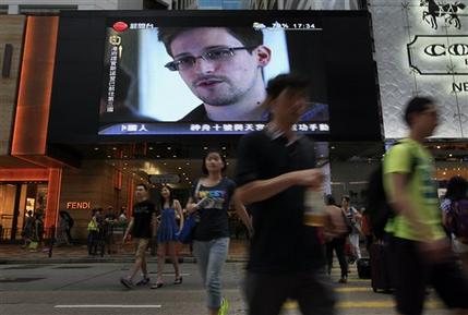 FILE - This June 23, 2013 file photo shows a TV screen shows a news report of Edward Snowden, a former CIA employee who leaked top-secret documents about sweeping U.S. surveillance programs, at a shopping mall in Hong Kong. President Barack Obama brushed aside sharp European criticism on Monday, suggesting all nations spy on each other, as the French and Germans expressed outrage over alleged U.S. eavesdropping on European Union diplomats. American analyst-turned-leaker Edward Snowden, believed to be stranded for the past week at Moscows international airport, applied for political asylum to remain in Russia. (AP Photo/Vincent Yu, File)