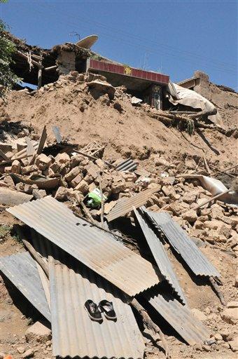 In this July 22, 2013 photo released by Xinhua News Agency, a damaged house stands in rubble following an earthquake that hit Majiagou Village of Minxian County, northwest China's Gansu Province. A strong earthquake struck near the surface in a dry, hilly farming area in western China early Monday, killing at least 54 people, injuring nearly 300, and shattering thousands of homes, the local government said. (AP Photo/Xinhua, Tu Guoxi) NO SALES