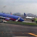 In this photo provided by Jared Rosenstein, a Southwest Airlines plane whose nose gear collapsed as it touched down on the runway is surrounded by emergency vehicles at LaGuardia Airport in New York on Monday, July 22, 2013. The plane was carrying 149 passengers and crew. (AP Photo/Jared Rosenstein) MANDATORY CREDIT