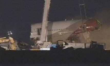 In this image from video provided by ABC7 News/KGO-TV a section of the fuselage of Asiana Flight-214 is removed at San Francisco airport early Friday morning July 12, 2013. Workers began clearing the wreckage early Friday. The Asiana flight crashed upon landing Saturday, July 6, at San Francisco International Airport, and two of the 307 passengers aboard were killed.  (AP Photo/ABC7 News/KGO-TV)