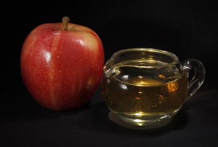 FILE - In this Sept. 15, 2011 photo, an apple and a pitcher of apple juice are posed together in Moreland Hills, Ohio. The Food and Drug Administration is setting a new limit on the level of arsenic allowed in apple juice, after more than a year of public pressure from consumer groups worried about the contaminant's effects on children. (AP Photo/Amy Sancetta, File)