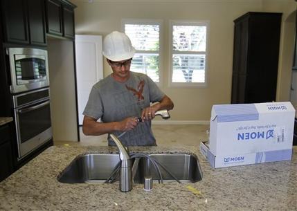 FILE - In this Friday, June 21, 2013 file photo, plumber Daniel Bordwell installs a kitchen faucet on a home under construction in Sacramento, Calif. Another solid month of hiring in June 2013 could signal the start of a stronger second half of the year for the U.S. economy. The Feds low interest-rate policies have encouraged more Americans to buy homes and cars. Theyve also helped boost stock and home prices in the first half of the year, increasing wealth and lifting consumers confidence to its highest level in 5½ years. (AP Photo/Rich Pedroncelli)