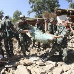 In this July 22, 2013 photo released by China's Xinhua News Agency, soldiers carry out a rescue mission after a strong quake jolted Lalu Village, Hetuo Township, Minxian County, northwest China's Gansu Province. A strong earthquake shook an arid, hilly farming area in northwest China sparked landslides and destroyed or damaged thousands of brick-and-mud homes Monday. (AP Photo/Xinhua, Cao Zhengping)