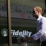 A pedestrian walks past a stock ticker at a Fidelity Investments office in Boston