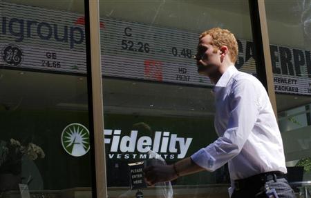 A pedestrian walks past a stock ticker at a Fidelity Investments office in Boston