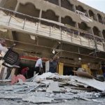 People gather at site of car bomb attack in Baghdad's al-Shaab district