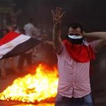 A supporter of Mursi makes the "Rabaa" or "Four" gesture during clashes at Mohandiseen in Cairo