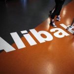 Employees stand on a logo of Alibaba (China) Technology Co. Ltd during a media tour organised by government officials at its headquarters on the outskirts of Hangzhou