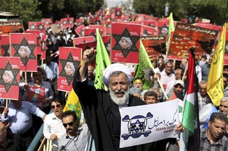 An Iranian cleric holding an anti-Israeli placard chants slogan
