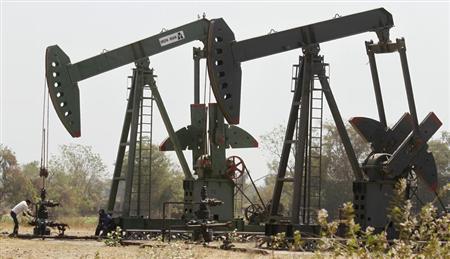 A worker examines the valve of a pump on an ONGC well on the western Indian city of Ahmedabad