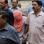 Delhi police officers escort a juvenile accused of rape