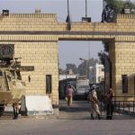Egyptian army soldiers guard with armoured personnel carriers in front of the main gate of Torah prison