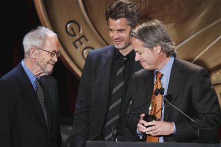 Executive producer Yost and actor Olyphant smile with writer Leonard after receiving a Peabody award for their work in "Justified" during the 70th annual Peabody Awards ceremony in New York