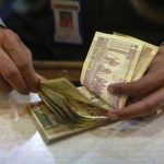 A cashier counts Indian rupee currency notes inside a bank in Mumbai