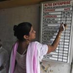 A shopkeeper writes currency exchange rates on a board inside a currency exchange shop in Kolkata