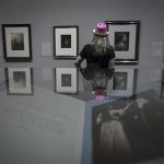 A woman looks at photographs displayed during an exhibition of Cameron's photographs at the Metropolitan Museum of Art in New York
