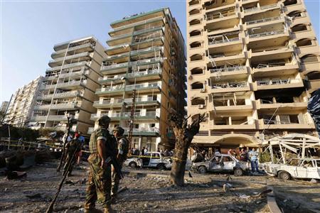 Lebanese army soldiers stand near damaged buildings caused by the two explosions outside two mosques in Lebanon's northern city of Tripoli