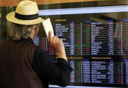 A man looks at an electronic board displaying stock index outside a bank in downtown Milan