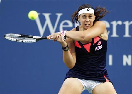 Bartoli of France hits a return to Halep of Romania during their women's singles match at the Cincinnati Open tennis tournament