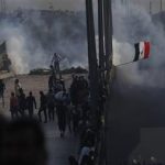 Pro-Mursi supporters flee from tear gas and rubber bullets fired by riot police during clashes in Cairo