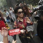 Singer Meng gestures as she is surrounded by the media outside a court in Beijing