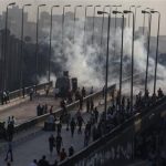 Pro-Mursi supporters flee from tear gas and rubber bullets fired by riot police during clashes in Cairo