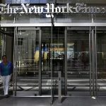 The sun peaks over the New York Times Building in New York