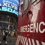 An emergency vehicle drives past the Nasdaq MarketSite in New York's Times Square
