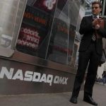 A man stands next to the Nasdaq MarketSite in New York