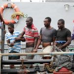 Suspected pirates are escorted aboard a naval ship after their arrest by the Nigerian Navy at a defence jetty in Lagos