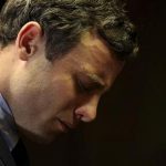 Olympic and Paralympic running star Oscar Pistorius reacts ahead of court proceedings at the Pretoria Magistrates court