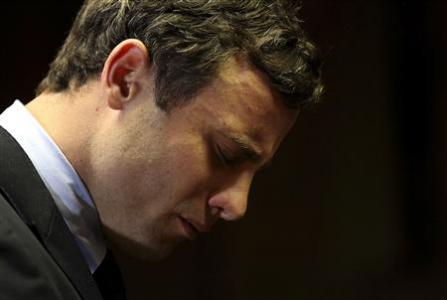 Olympic and Paralympic running star Oscar Pistorius reacts ahead of court proceedings at the Pretoria Magistrates court