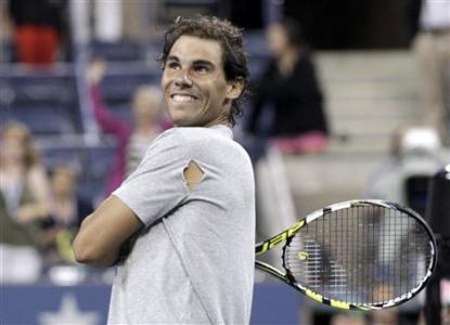 Rafael Nadal of Spain hits tennis balls into the crowd after defeating Rogerio Dutra Silva of Brazil at the U.S. Open tennis championships in New York