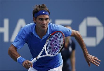 Federer of Switzerland chases down a return to Berlocq of Argentina at the U.S. Open tennis championships in New York