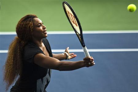 Williams of U.S. returns ball while she attends an exhibition game after Draw Ceremony before start of 2013 U.S. Open tennis tournament in New York