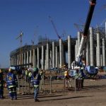 Workers are seen in front the construction site of Eskom's Medupi power station, a new dry-cooled coal fired power station, in Limpopo province