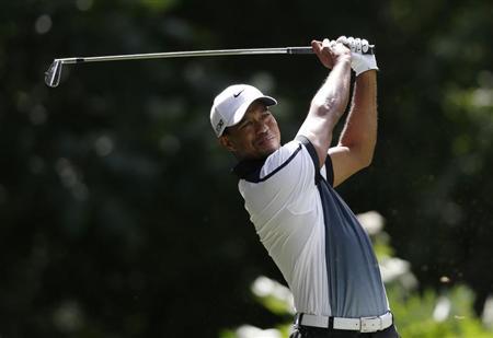 Tiger Woods of the U.S. tees off on the third hole during the third round of the 2013 PGA Championship golf tournament at Oak Hill Country Club in Rochester