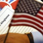 The Oath of Allegiance is held next to an American flag during a Special Naturalization Ceremony at the U.S. Treasury Department in Washington