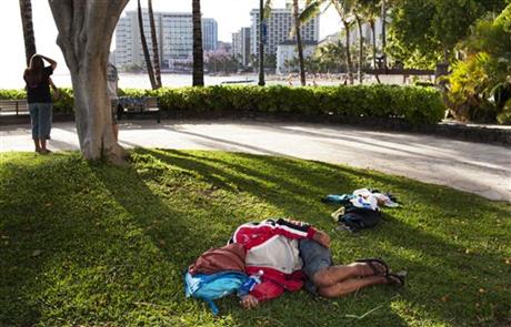 a man sleeps on the ground near Waikiki Beach