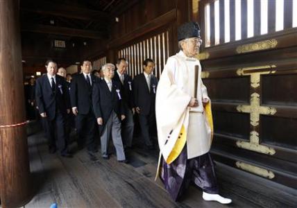 A group of lawmakers are led by a Shinto priest as they visit the Yasukuni Shrine in Tokyo