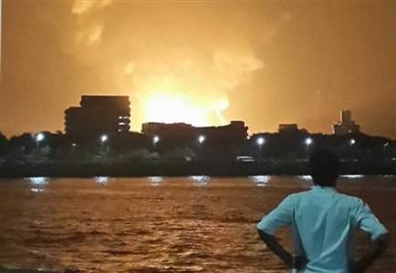 A man watches Indian Navy submarine INS Sindhurakshak on fire in Mumbai