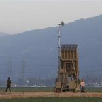 An Israeli soldier walks away from an Iron Dome rocket interceptor battery deployed near the northern Israeli city of Haifa