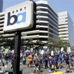 In this file photo from Monday, July 1, 2013, striking Bay Area Rapid Transit workers picket as they close the intersection of 14th & Broadway on Monday, July 1, 2013, in downtown Oakland, Calif. San Francisco Bay Area commuters braced for the possibility of another train strike as the Bay Area Rapid Transit agency and its workers approached a deadline to reach a new contract deal. The two sides were set to resume negotiations at noon on Thursday, Aug. 1, but did not appear close to an agreement. (AP Photo/Ben Margot)