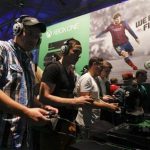 Visitors play "FIFA 14" with the Xbox One at the Microsoft Games exhibition stand during the Gamescom 2013 fair in Cologne