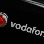 A Vodafone mobile internet dongle is seen connected to a laptop in London