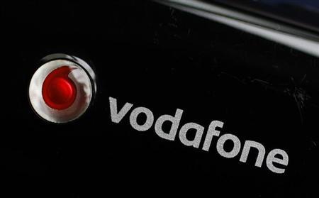 A Vodafone mobile internet dongle is seen connected to a laptop in London