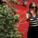 Actress Johansson waves as she arrives for a news conference for the movie "Under the Skin", directed by Glazer, during the 70th Venice Film Festival in Venice